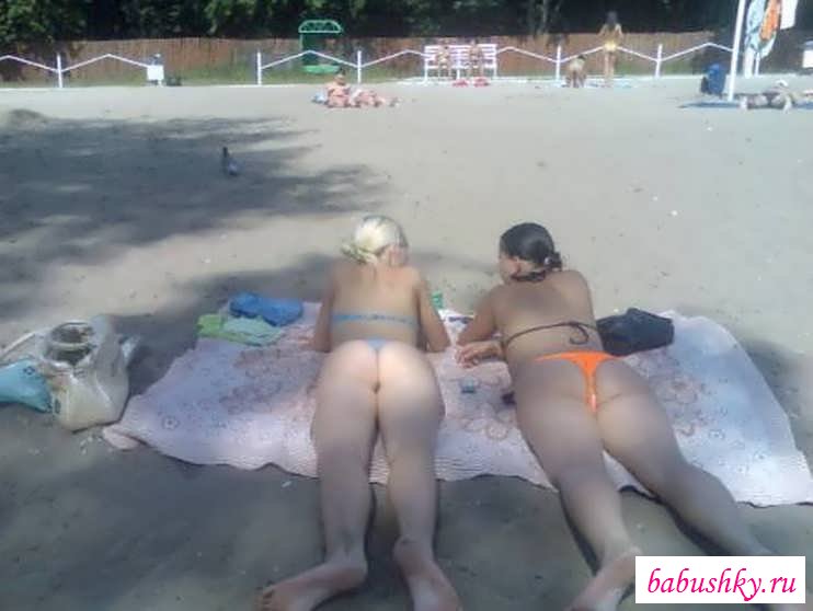Девчонки загорают на берегу с голыми сиськами